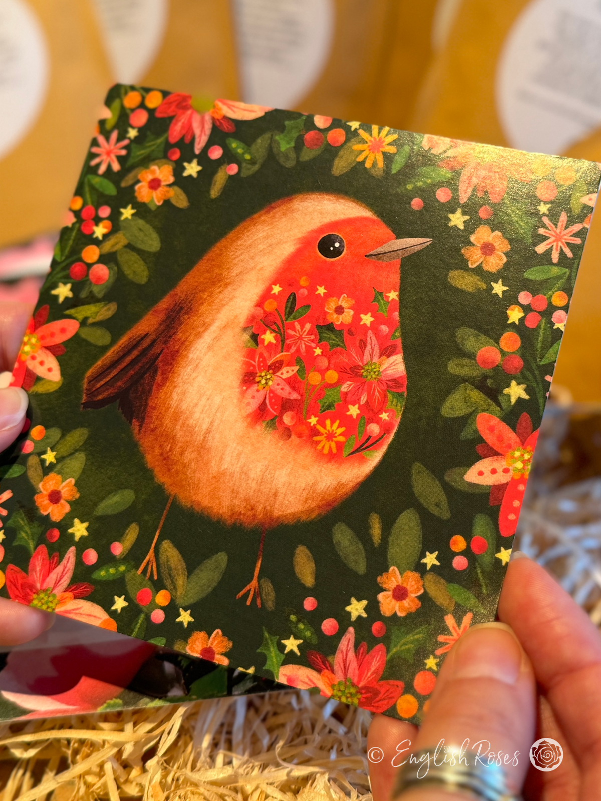 A greetings card with a cute robin design with festive flowers and foliage.