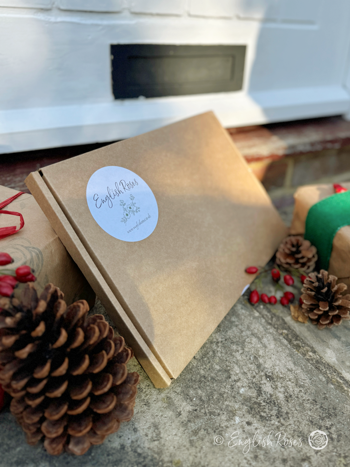 An English Roses Christmas Letterbox gift on a doorstep.