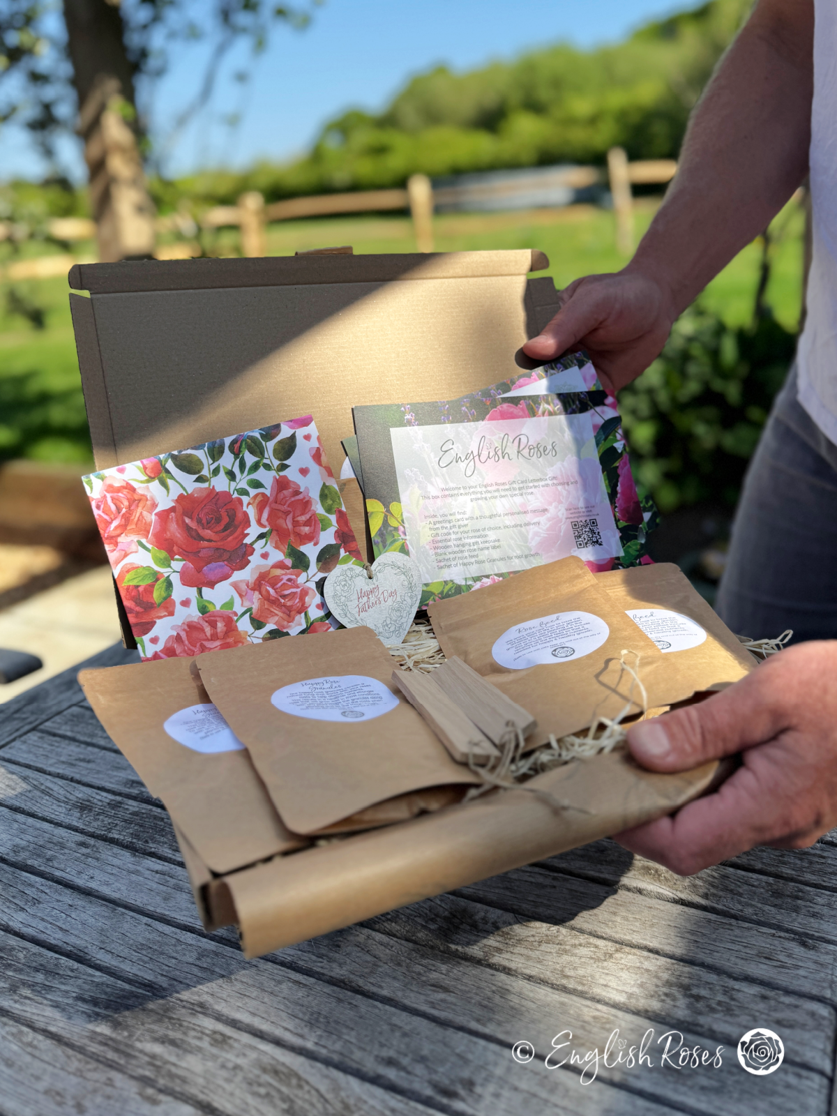 A father holding English Roses Father's Day Letterbox gift 2 Rose gift